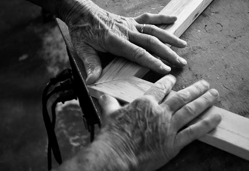 Close-up of traditional mortise-and-tenon joinery being aligned by hand at the DKD workshop.