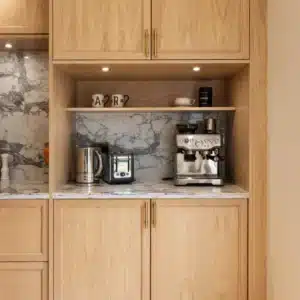 Built-in oak coffee station with espresso machine, kettle, toaster and open shelving