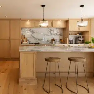 Contemporary stained oak kitchen with stone island, brass fittings and pendant lighting